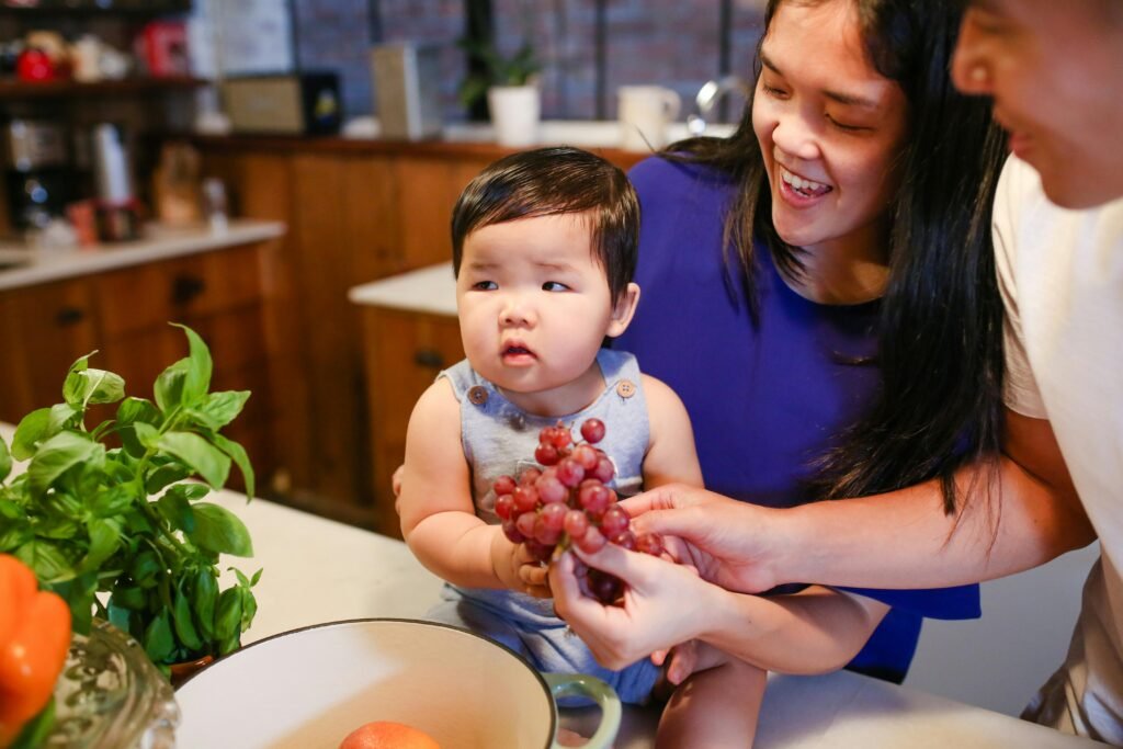 Woman in Blue Shirt Carrying Baby in White and Red Shirt